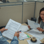 Business professional reviewing insurance policy exclusions and coverage gaps at office desk